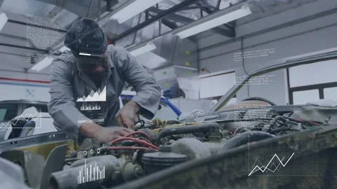 Male tech leaning over car hood, adjusting red wires while data overlays Stock Footage 332504983