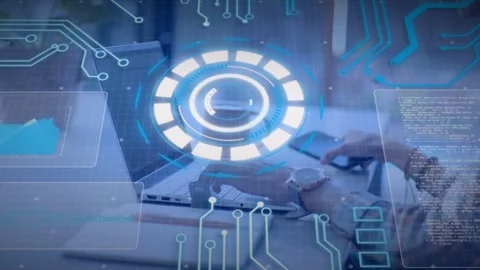 Male tech worker typing at laptop, reaching phone, tapping, syncing with HUD Stock Footage 334729141