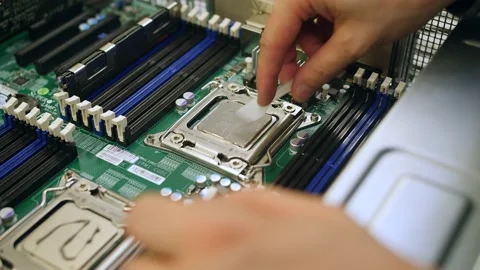 A male technical engineer in a server hardware assembly room applies thermal pas Stock-Footage 208297149