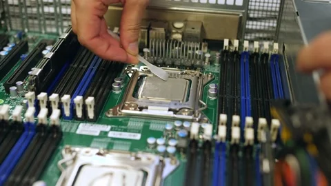 A male technical engineer in a server hardware assembly room applies thermal pas Stock-Footage 208297174