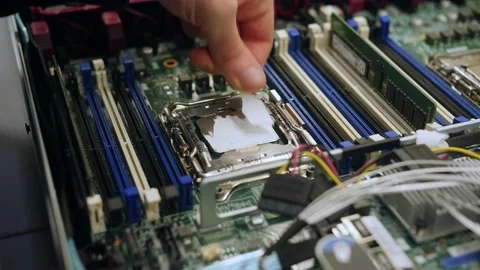 A male technical engineer in a server hardware assembly room applies thermal pas Stock-Footage 208297305