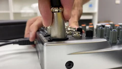 Male technician hand pull microphone plug from audio equipment mixer console Stock Footage 254153696