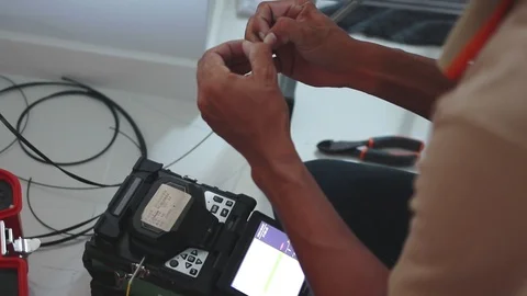 Male technician peeling protective layer off from a fiber optic cable Stock Footage 102189883