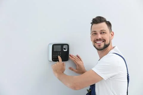 Male technician programming alarm system indoors Stock Photos