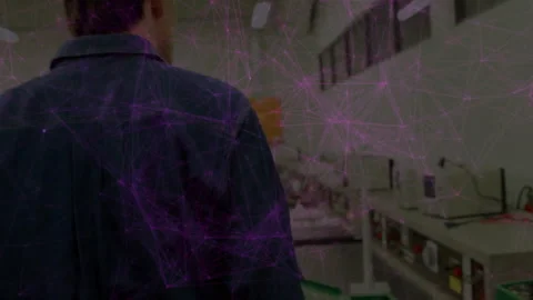 Male technician working in electronics lab, with purple network nodes overlaying Stock Footage 307434059