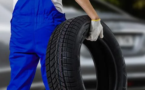 Male tire changer In the process of checking the condition of new tires that are Stock Photos
