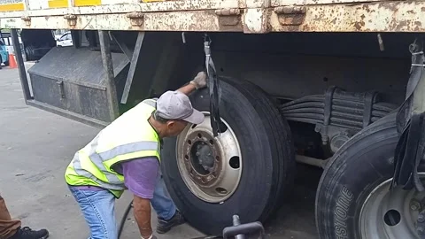 Male Tire Technician Manually Installing New Tire in Tire Workshop Area Stock Footage 309306897