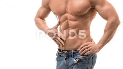 Male torso with perfect abs. Man in blue jeans touching his abs isolated on Stock Photos