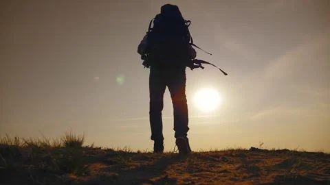A male tourist with a backpack walks at sunset, enjoying the picturesque Stock-Footage 151203053