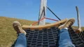 Male tourist swinging in hammock, lazy free time, refreshment on peaceful meadow HD Footage