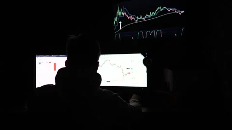 Male trader analyzing commodities and foreign exchange charts at evening. Stock-Footage 309299458
