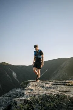 Male trail runner hikes on granite in White Mountains, New Hampshire Stock Photos