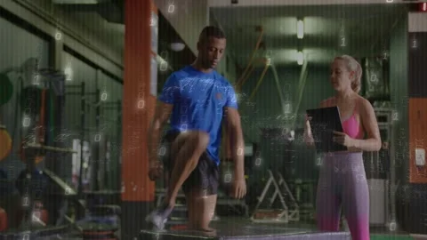 Male trainee doing singleleg plyo jumps on box after gym coach cueing timing on Stock Footage 332613862