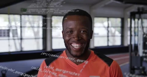 Male trainer reacting to scrolling code overlay showing performance data across Stock Footage 331700973