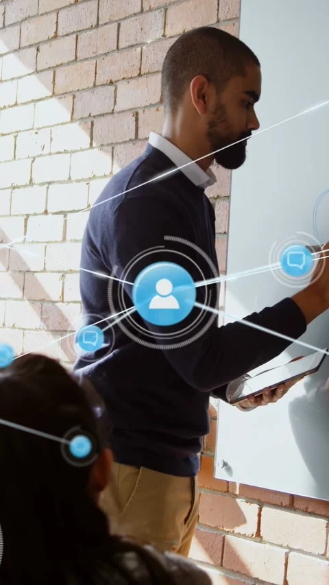 Male trainer writing with tablet causing blue icons linking notes while woman Stock Footage 333005985