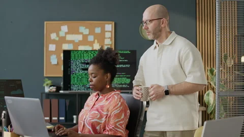 Male Tutor Checking Work of Female Software Engineer in Office Stock Footage 306848805