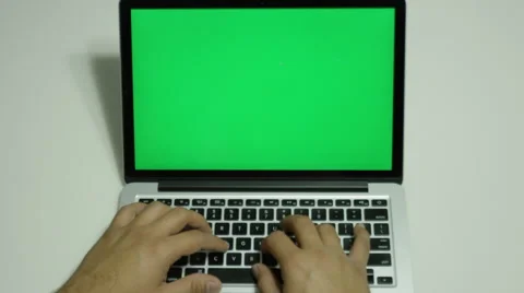 Male typing on a computer with a green screen Stock Footage 68500961