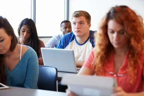 Male university student using laptop in classroom Stock Photos