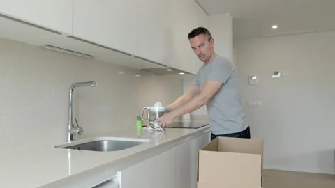 Male unpacking boxes in the kitchen Video stock 236691934