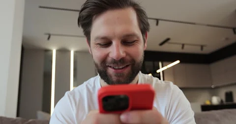Male using smartphone sitting on couch at home. Man scrolling smartphone Video stock 269125787