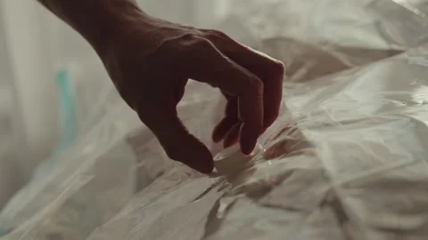 Male using vacuum cleaner for removing air from plastic bag filled with cozy Stock Footage 304879096