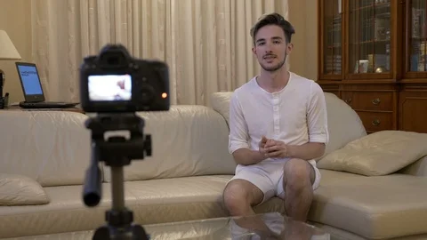 Male vlogger recording a video tutorial at home on couch about online busines Stock Footage 86138324