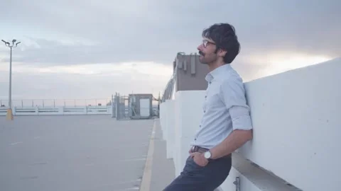 Male waiting checking time on rooftop in sunset take 1 Stock Footage 293579711