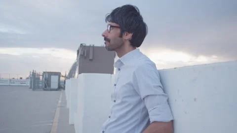 Male waiting thinking missing someone on rooftop in sunset medium take 1 Stock Footage 293588331