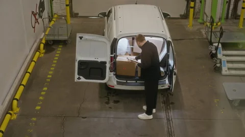 Male Warehouse Worker Checking Boxes in Delivery Van with Clipboard Stock Footage 340282902