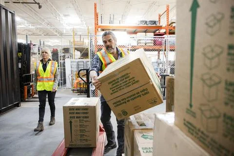 Male warehouse worker stacking boxes Stock Photos
