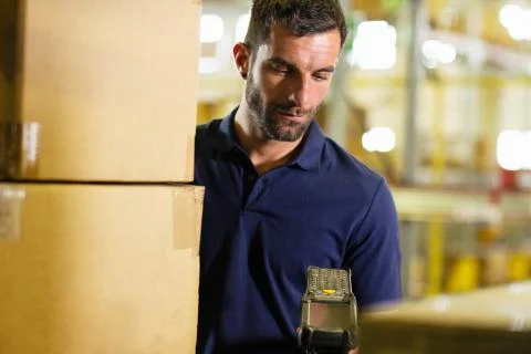 Male warehouse worker using barcode scanner in distribution warehouse Stock Photos