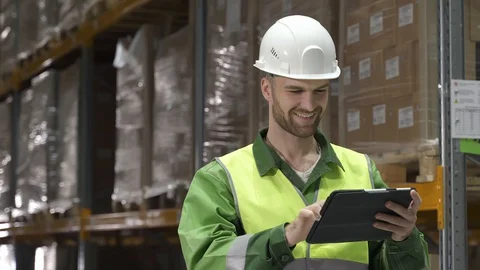 Male warehouse worker using digital tablet computer. man manager smiling in Stock Footage 127675271