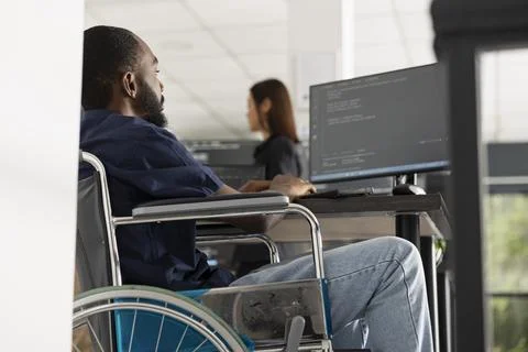 Male wheelchair user debugging software and reviewing website code 写真素材