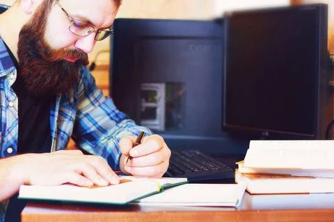 Male work computer pen write bearded man sitting at a table and working wi... Foto stock