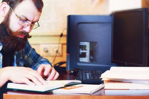 Male work computer pen write bearded man sitting at a table and working wi... Foto stock