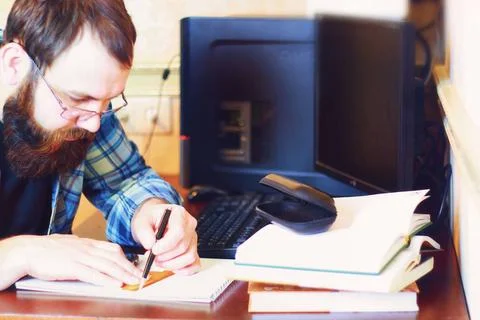 Male work computer pen write bearded man sitting at a table and working wi... Foto stock