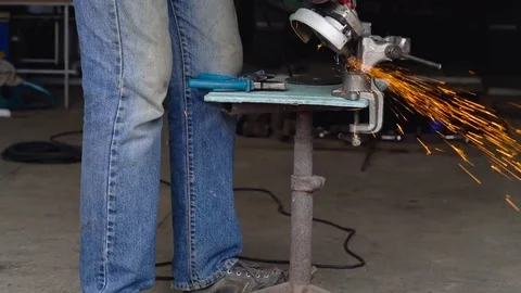 Male worker with angular grinding machine is cutting the metal Stock Footage 78424174
