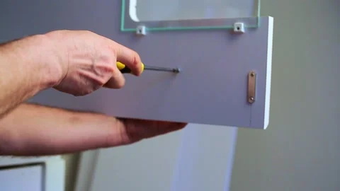 Male worker Carpenter hands Fixing furniture fastened with screws by screwdriver Stock Footage 167236718