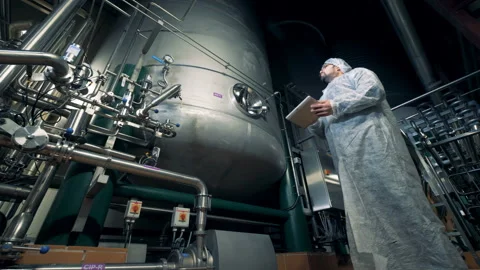 Male worker is controlling functioning process of brewing equipment Video stock 98962118