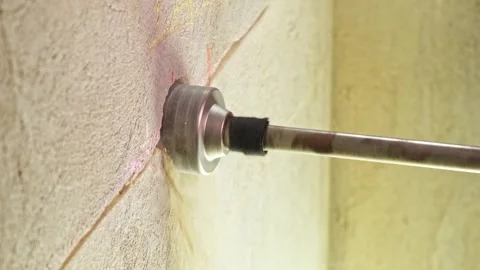 A male worker is drilling a socket in the wall with a drill electrical outlet Stock Footage 271354707