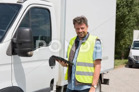 Male worker in front truck using mobile phone Stock Photos
