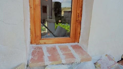 Male worker grouting a brick windowsill during house renovation Video stock 346167988
