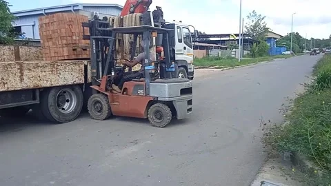 A Male Worker Loads Red Bricks With A Forklift Stock Footage 304963526