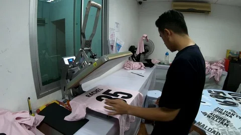Male worker on Pressing The Transfer Element On A T-Shirt Stock Footage 106868560