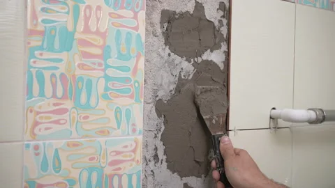 Male worker professional master laying ceramic tiles on the wall in the bathroom Stock Footage 199842027