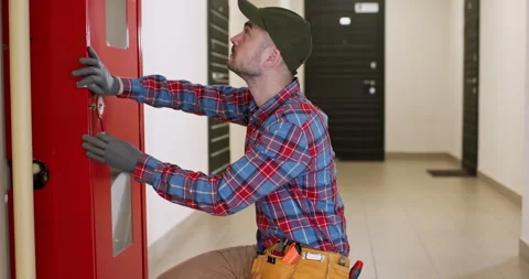 Male worker pulls out to open fire safety cabinet with knife 動画素材 247171461