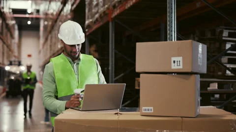 Male Worker Scanning Box with Barcode Scanner Using Laptop at Warehouse Stock Footage 247714605