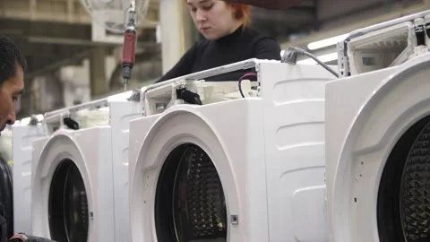 Male worker with screwdriver assembles washing machine Stock Footage 246582052