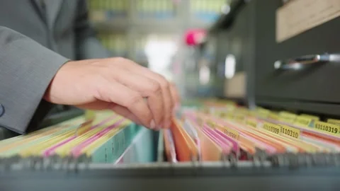 A male worker searching for documents in the office filing cabinet Stock Footage 147956741