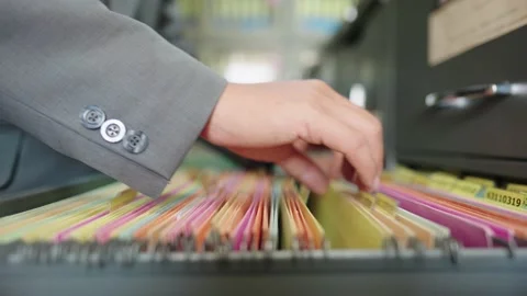 A male worker searching for documents in the office filing cabinet Видео 147956746